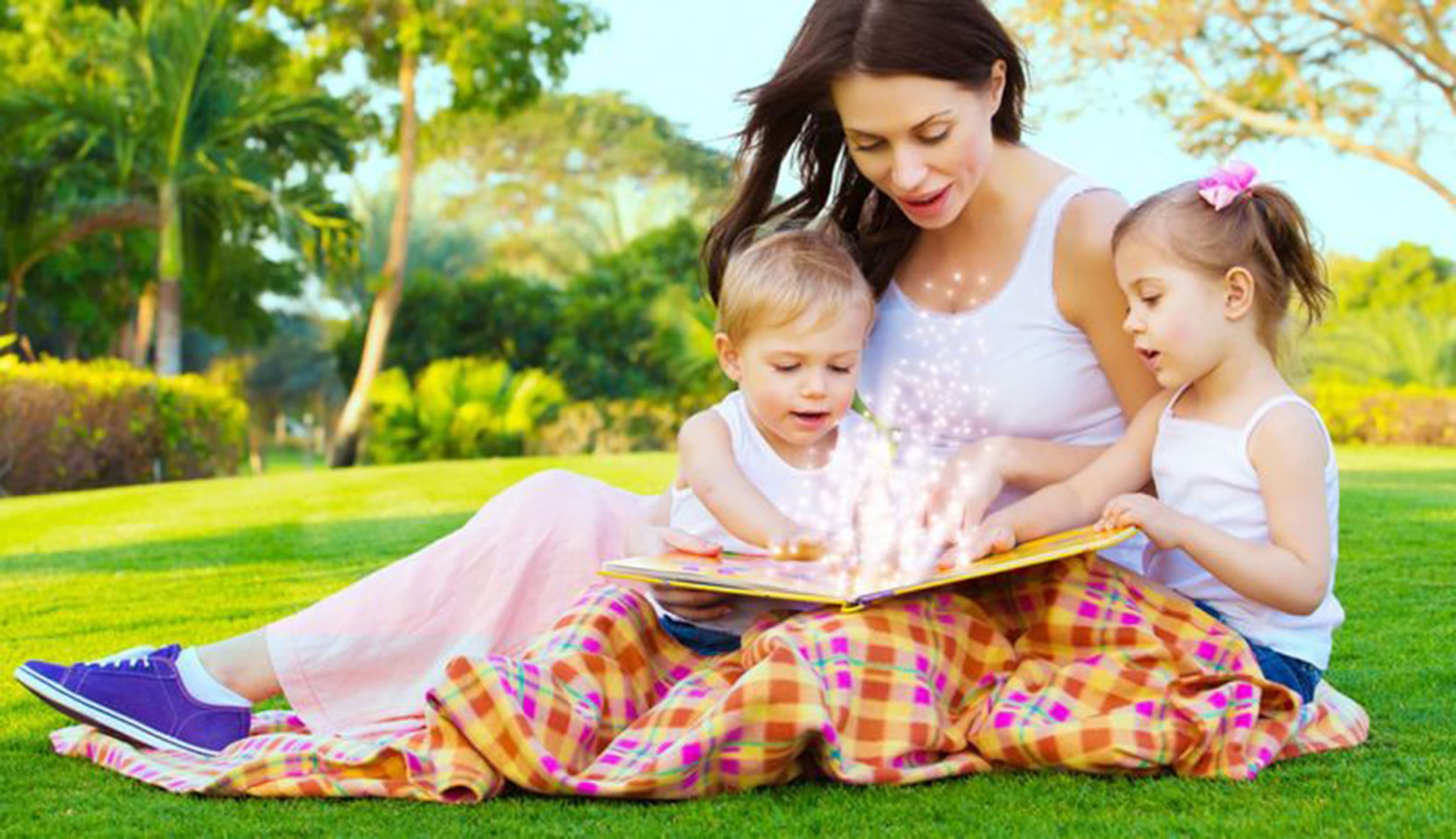 Mãe com crianças lendo um livro.