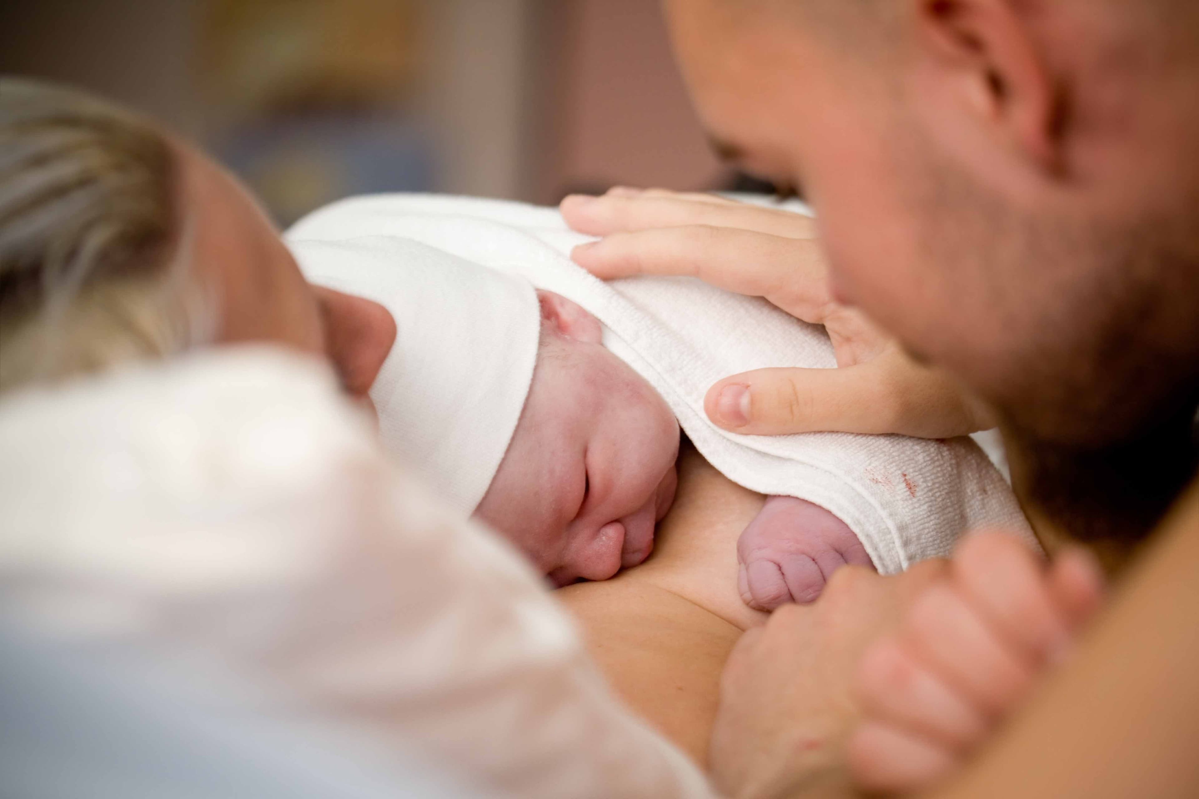 Mãe e pai com seu filho recém-nascido.